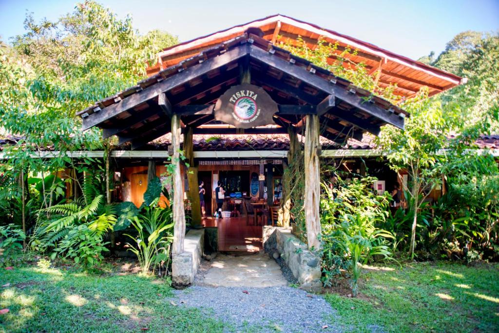 a building with a wooden roof in a garden at Tiskita Jungle Lodge in Pavones