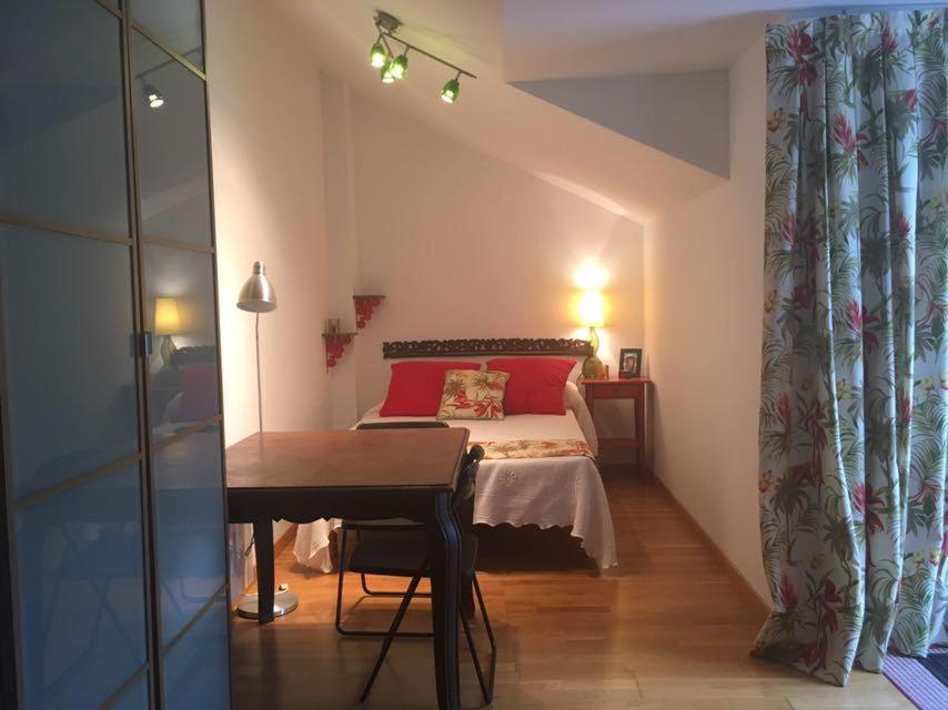 ウンケラにあるATICO 3 DORMITORIOSのベッドルーム1室(赤い枕とテーブル付きのベッド1台付)