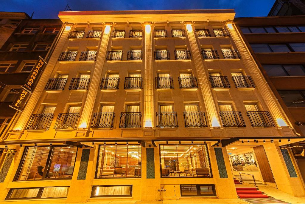 Un grand bâtiment avec des lumières à l'avant dans l'établissement Mukarnas Taksim Hotel, à Istanbul