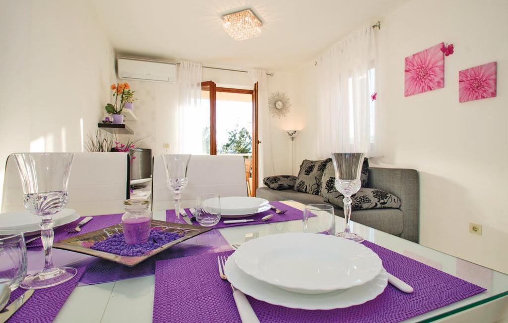 una mesa con platos y gafas sobre un mantel púrpura en Apartment Rosana, en Rabac