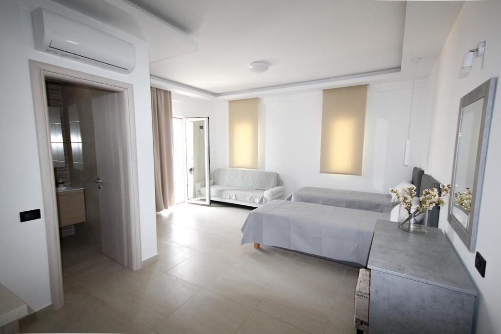 スタリスにあるXenia Stalis Apartmentsの白いベッドルーム(ベッド1台、ソファ付)