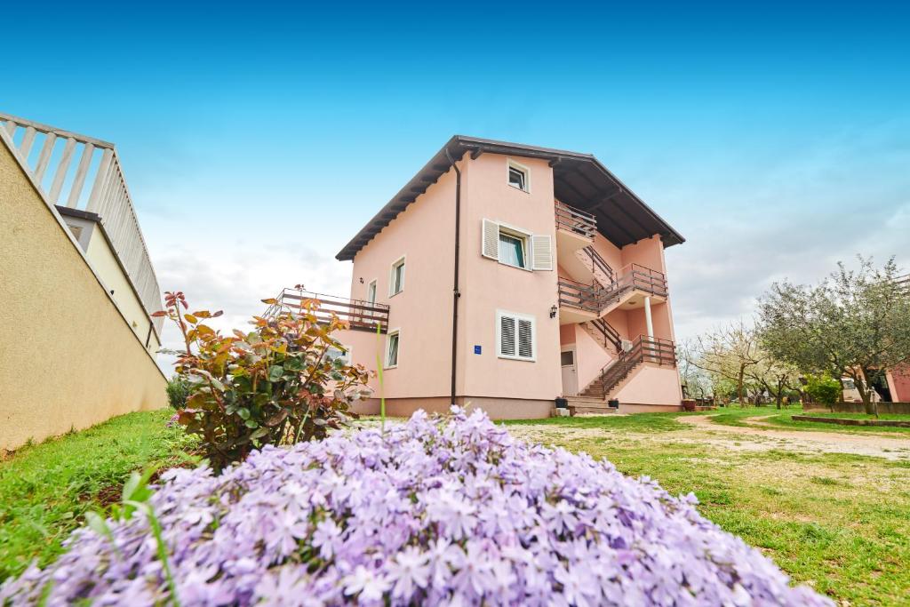 uma casa com flores roxas em frente em App Ružica Finida em Umag