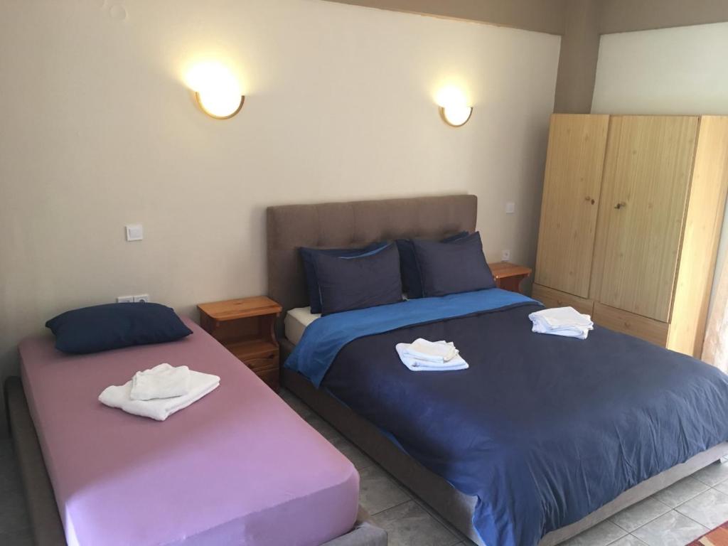 a bedroom with two beds with towels on them at Kastraki Studios in Stoupa