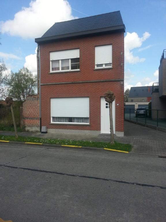 a red brick house with white doors and a street at The best known village of Belgium in Puurs