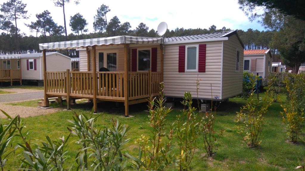 ein kleines Haus mit einer Veranda und einer Terrasse in der Unterkunft Les Dunes de Contis in Saint-Julien-en-Born