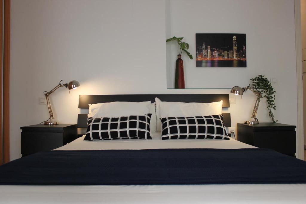 a bedroom with a large bed with two lamps at Apartamento Alfaqueque in Seville