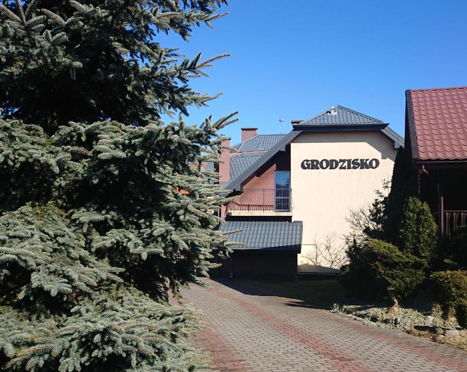 a building with a sign on the side of a road at Grodzisko pokoje do wynajęcia in Krynica Morska