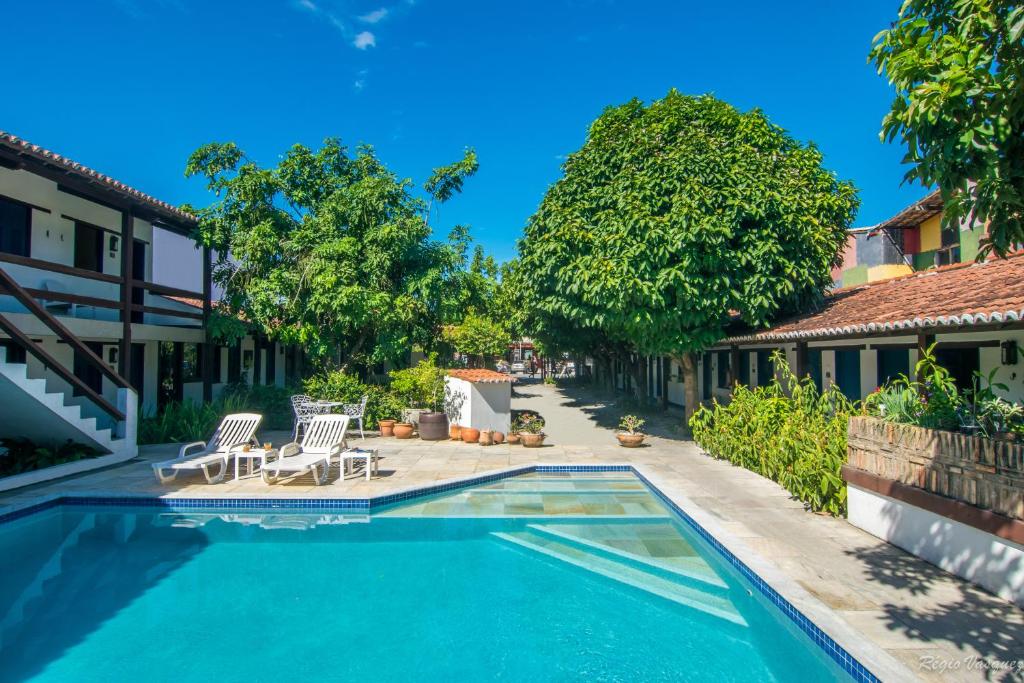 a swimming pool in front of a house at Pousada Sao Luiz in Porto Seguro