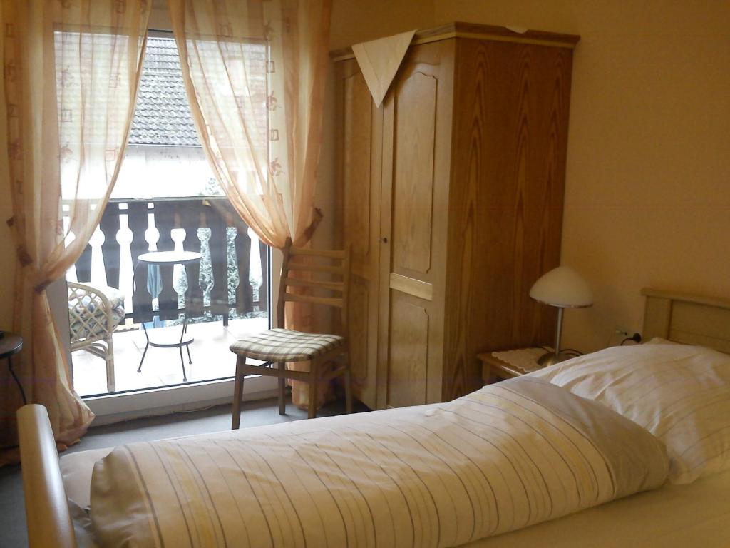 a bedroom with a bed and a window with a balcony at Hotel zur Küferschenke in Nierstein