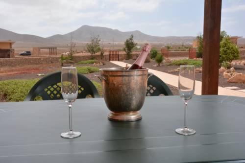 una mesa con dos copas de vino y un cubo en ella en Casa Serena en Llanos de la Concepción