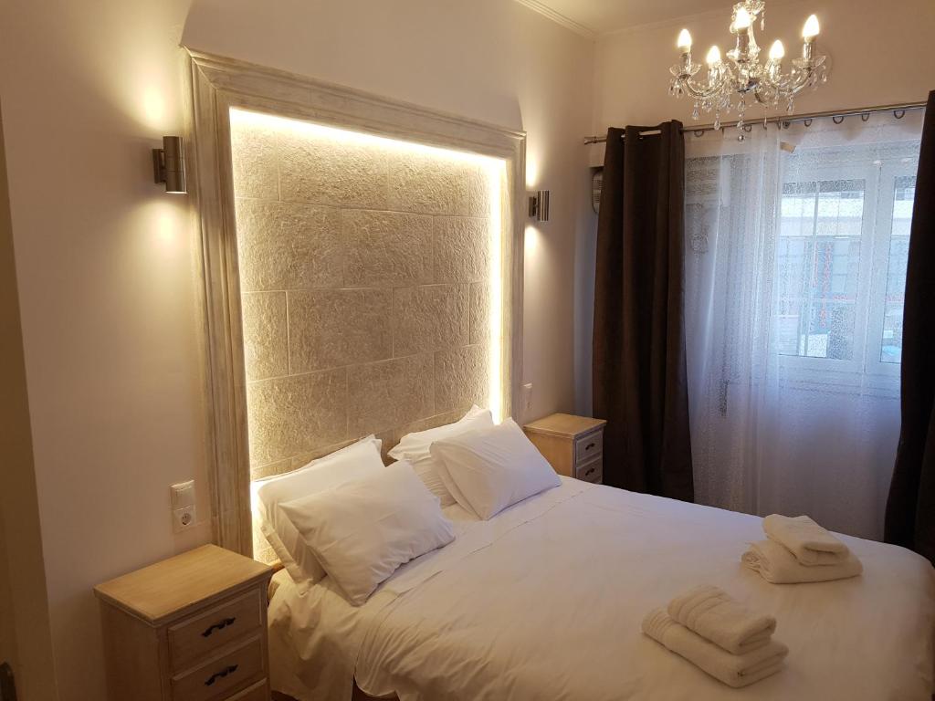 ein Schlafzimmer mit einem weißen Bett mit zwei Handtüchern darauf in der Unterkunft JOHN BEAUTY 50m2, METRO and ACROPOLIS 5' in Athen