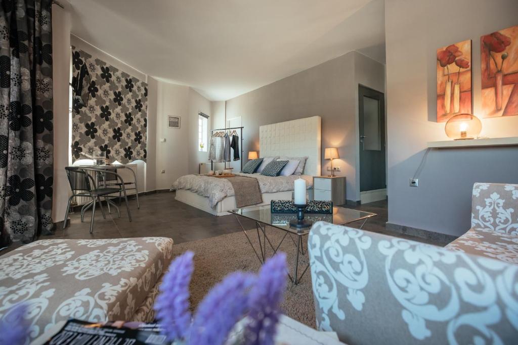 Private Place Nafplio Exostis في Ária: غرفة معيشة مع سرير وطاولة