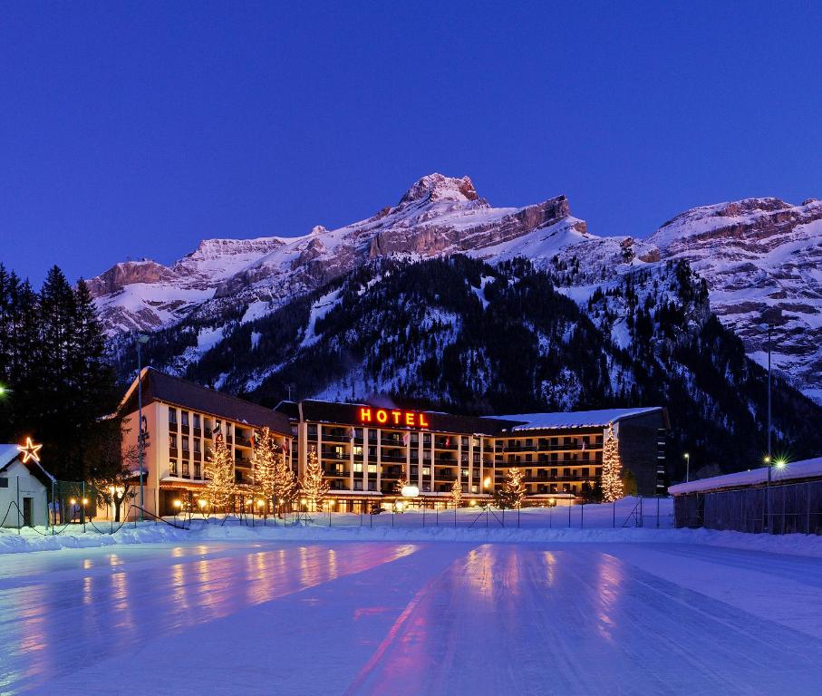 a hotel in front of a mountain at night at Eurotel Victoria Les Diablerets Superior in Les Diablerets