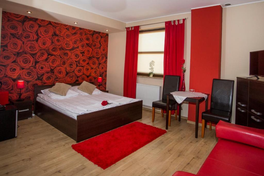 a bedroom with a bed and a red wall at Noclegi M4 in Żyrardów