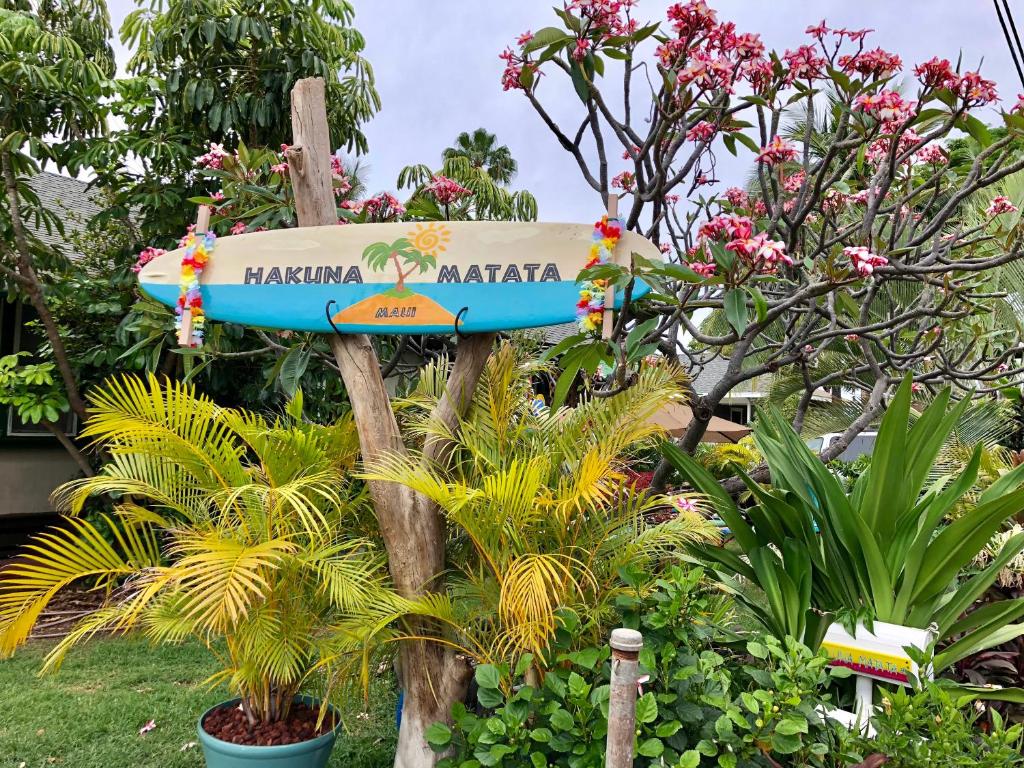 a sign in a garden with plants and flowers at Hakuna Matata Maui Hostel in Lahaina