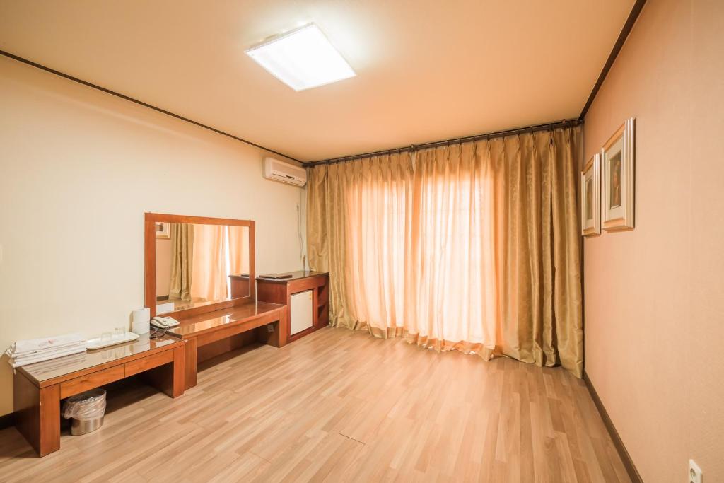 Habitación con escritorio y espejo. en Daea Ulleung Resort en Ulleung