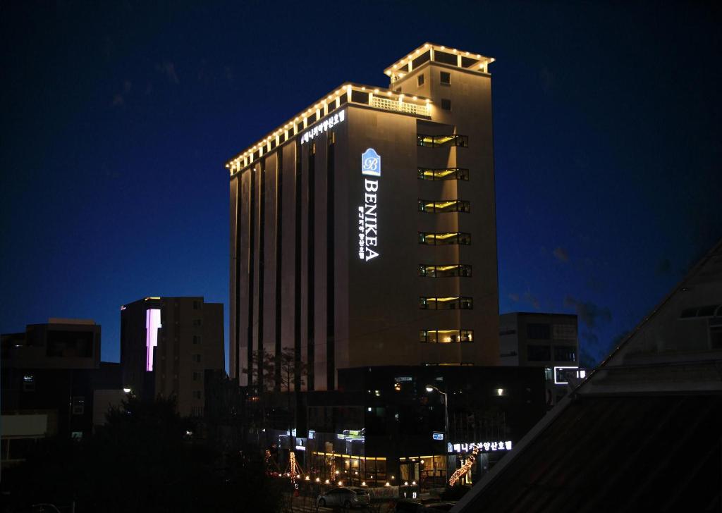 a tall building with a sign on it at night at Benikea Hotel Yangsan in Yangsan