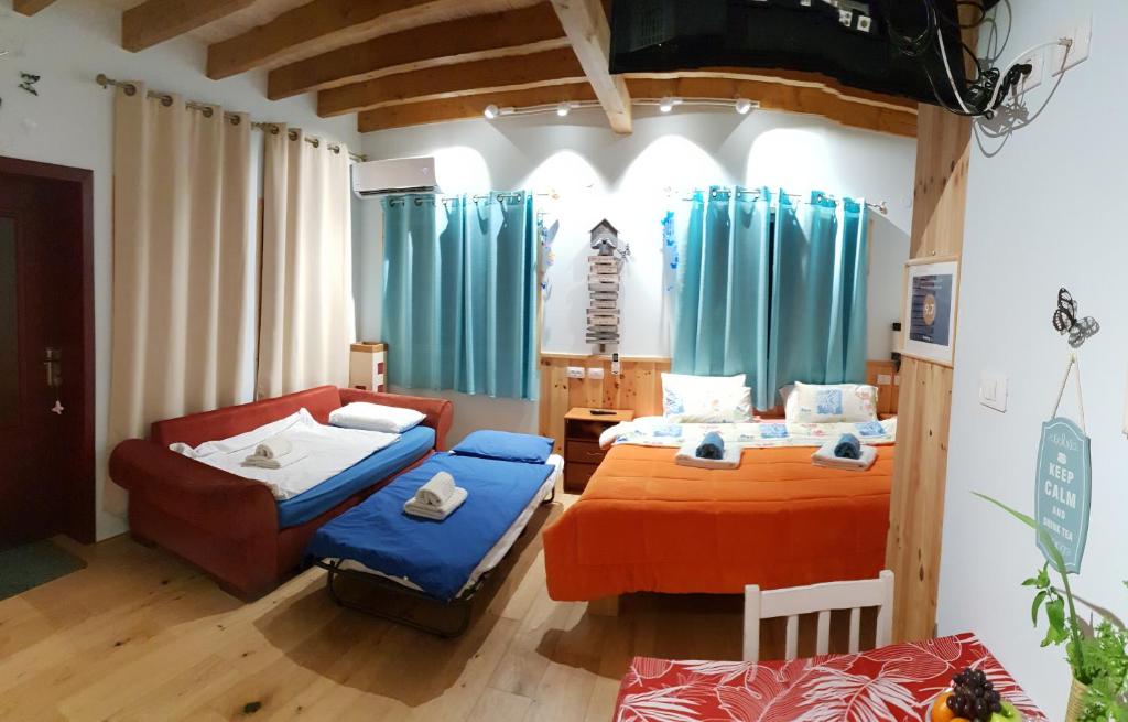 1 dormitorio con 2 camas y sofá en The Butterflies Wood House en Reshafim