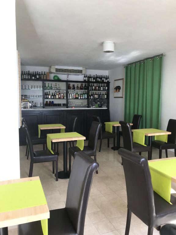 a dining room with tables and chairs and green curtains at Albergo Luna di Marzo in Volastra