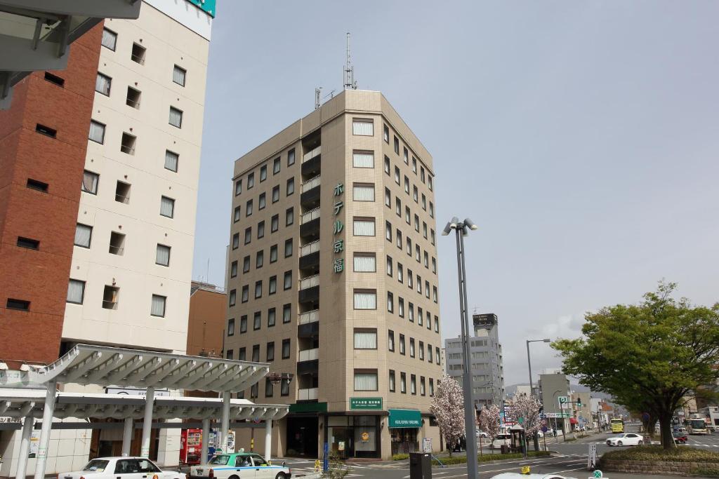 a tall building on a city street with buildings at Hotel Keifuku Fukui Ekimae in Fukui