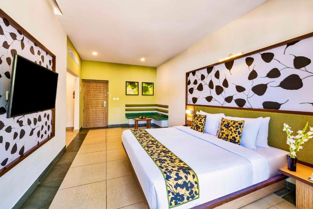 a bedroom with a bed and a flat screen tv at Sterling Wayanad in Sultan Bathery