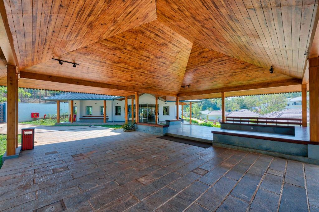 a large pavilion with a wooden ceiling and large windows at Sterling Wayanad in Sultan Bathery