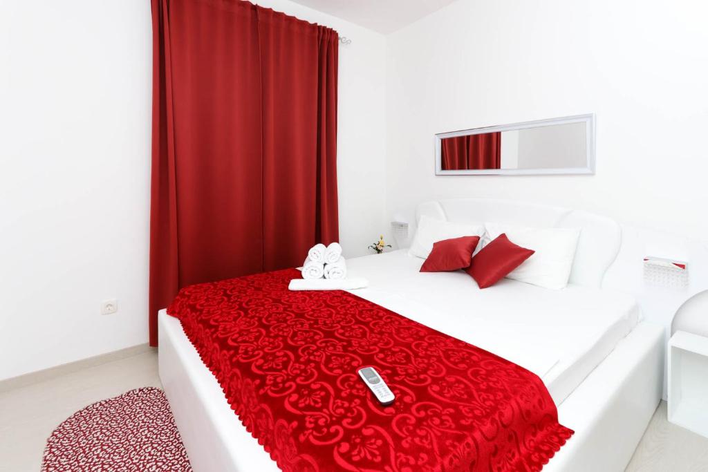 a bedroom with a bed with a red blanket at Apartments Castello in Kotor