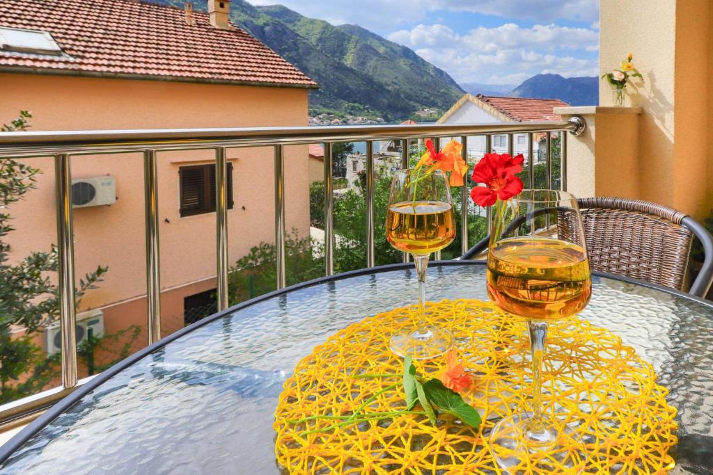 two glasses of wine on a table on a balcony at Apartments Castello in Kotor