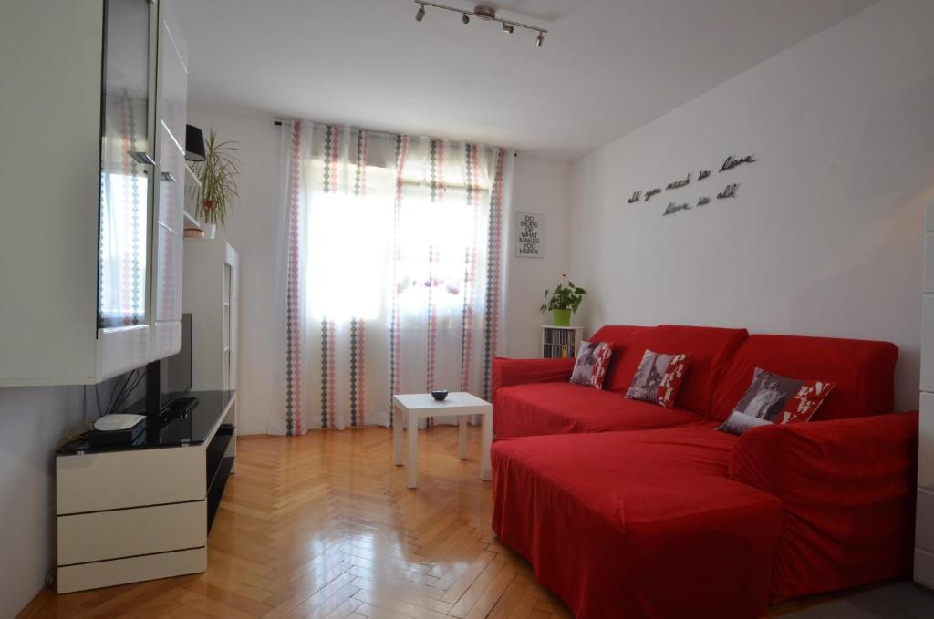 a living room with a red couch and a television at Apartman Terzić in Rovinj