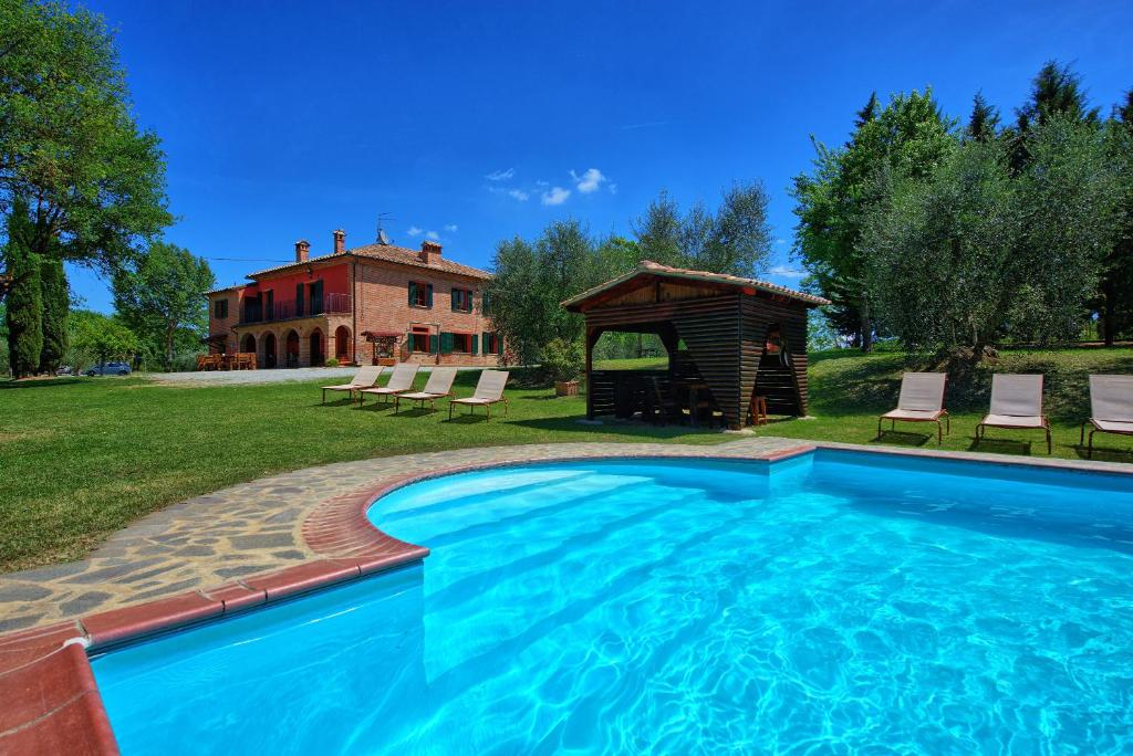 una piscina con cenador y una casa en Villa Mario by PosarelliVillas, en Lucignano
