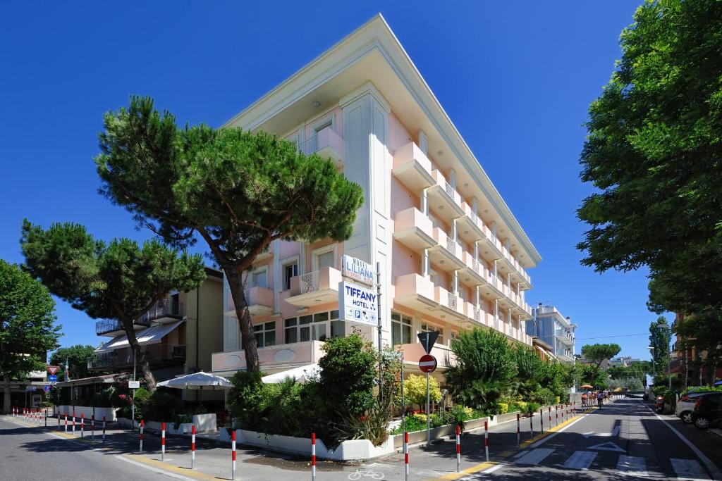 un grand immeuble situé sur le côté d'une rue dans l'établissement Hotel Tiffany, à Rimini