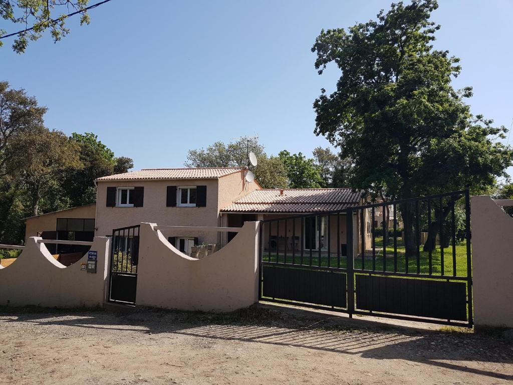une maison avec un portail et une clôture dans l'établissement Corsica Paddock, à Prunelli-di-Fiumorbo