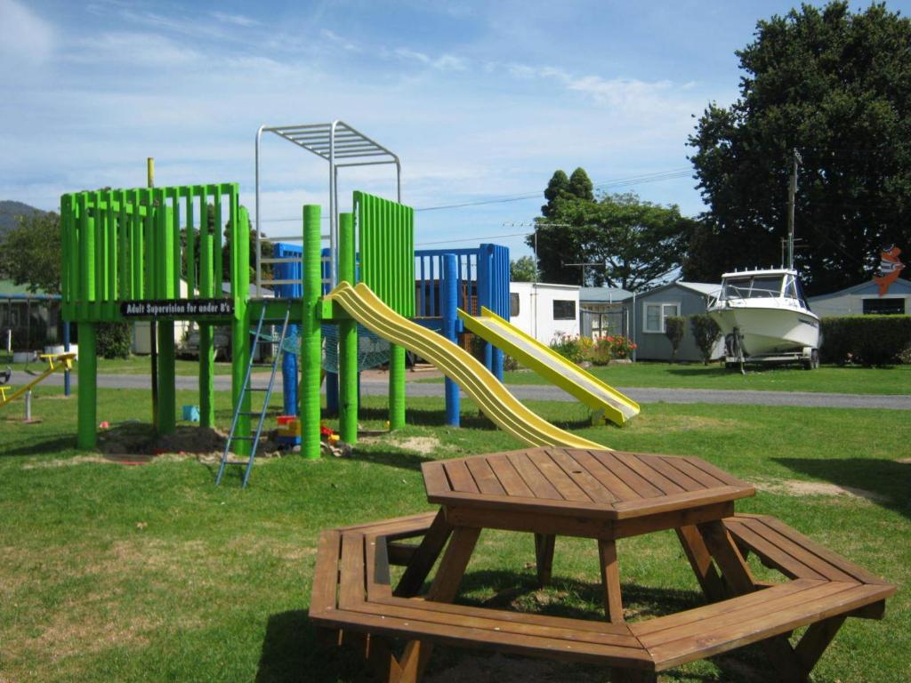 a playground with a slide in a park at Te Puru Holiday Park in Thames