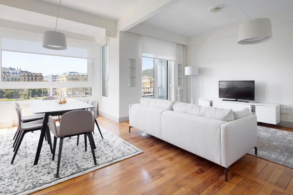 a living room with a white couch and a table and chairs at Okendo by FeelFree Rentals in San Sebasti&aacute;n
