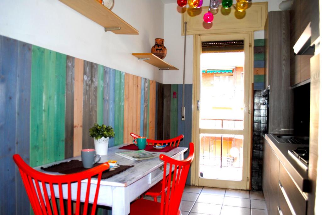 una cocina con sillas rojas y una mesa con barra en Bnbook - Ferrarin Apartment en Sesto Calende