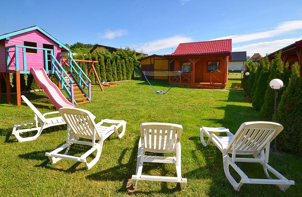 a group of chairs in a yard with a playground at AMANDA Domki letniskowe in Darłowo