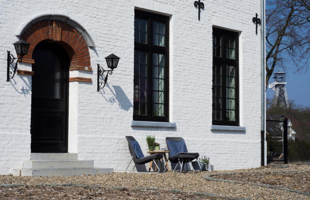 two chairs and a table in front of a building at B&B Eikenlaan 12 in Genk
