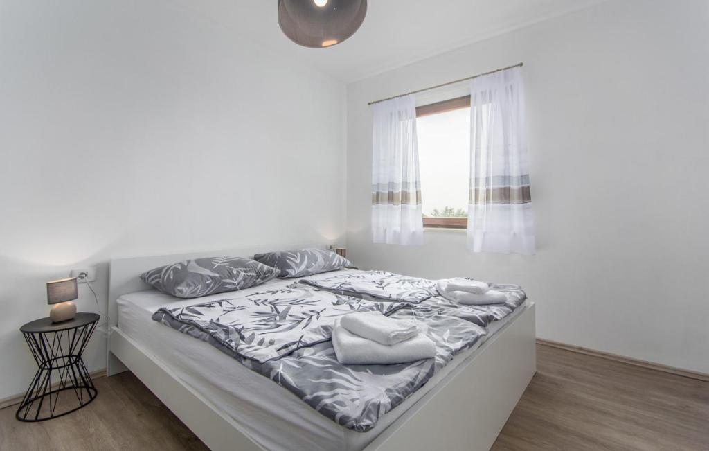 a white bedroom with a bed and a window at Apartments Katja in Marčana