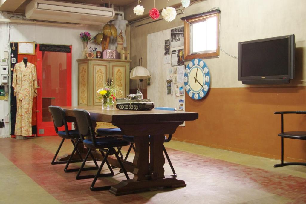 a room with a table with chairs and a tv at Kichinan in Osaka