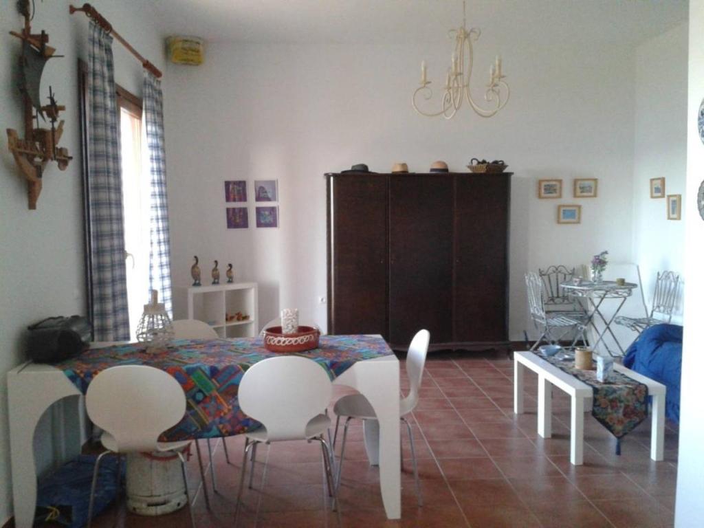a dining room with a table and white chairs at Marvelous Sea View Eco Apt in Ammouliani