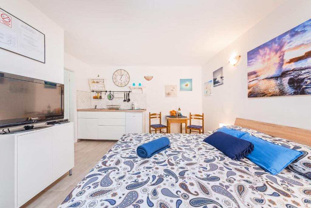ein Schlafzimmer mit einem großen Bett und einem TV in der Unterkunft Degrassi Square Apartments in Vrsar