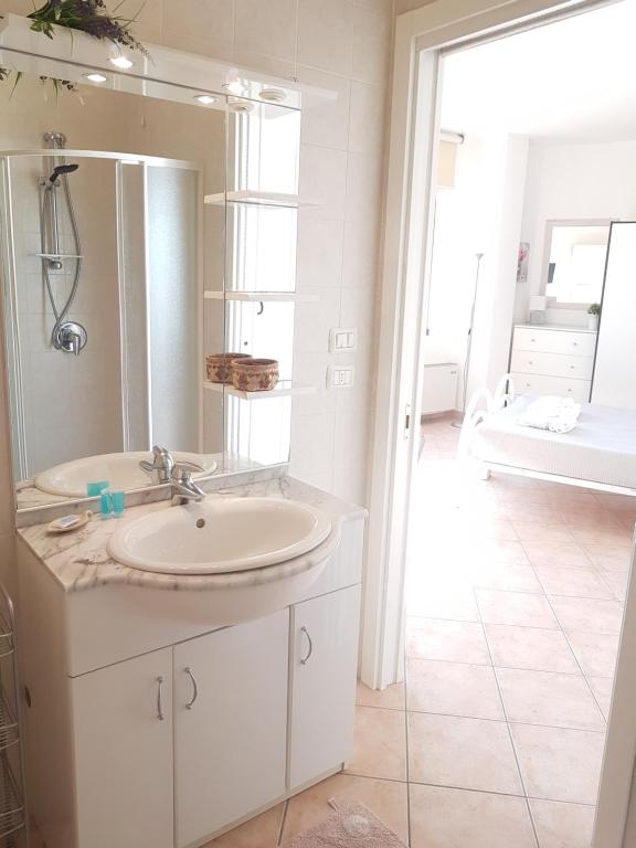 W łazience znajduje się umywalka, lustro i wanna. w obiekcie Home Suite Home w mieście Cavaion Veronese