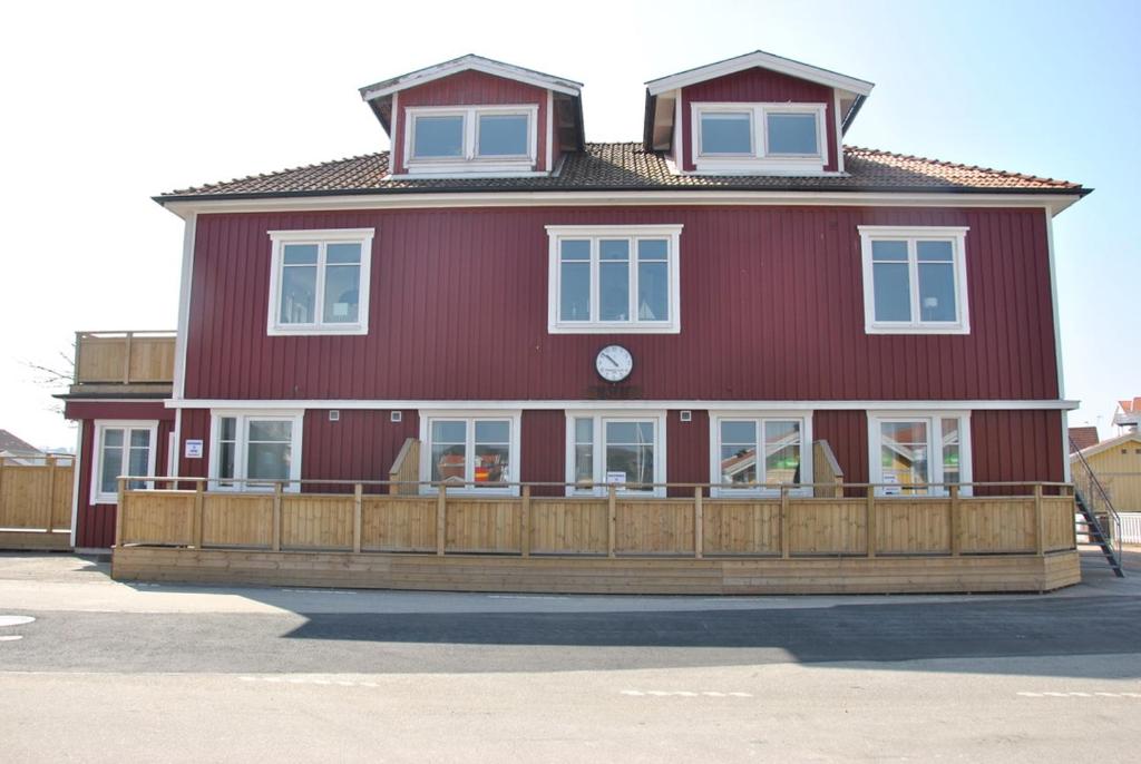 uma casa vermelha com uma cerca de madeira em frente em Sjöhuset em Ellös