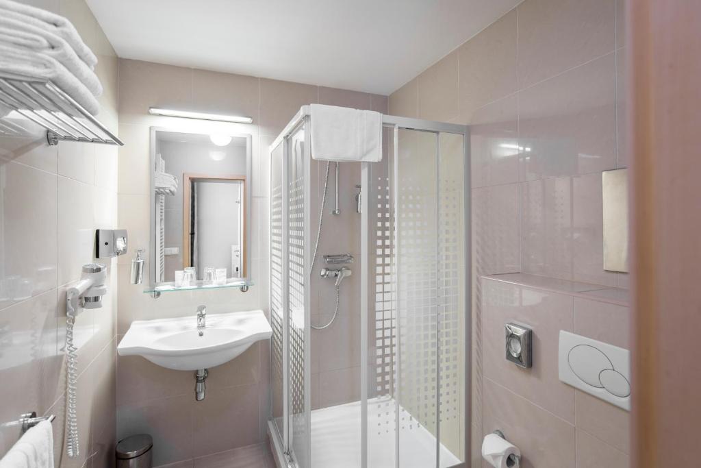 a bathroom with a sink and a shower at Hotel Páv in Prague