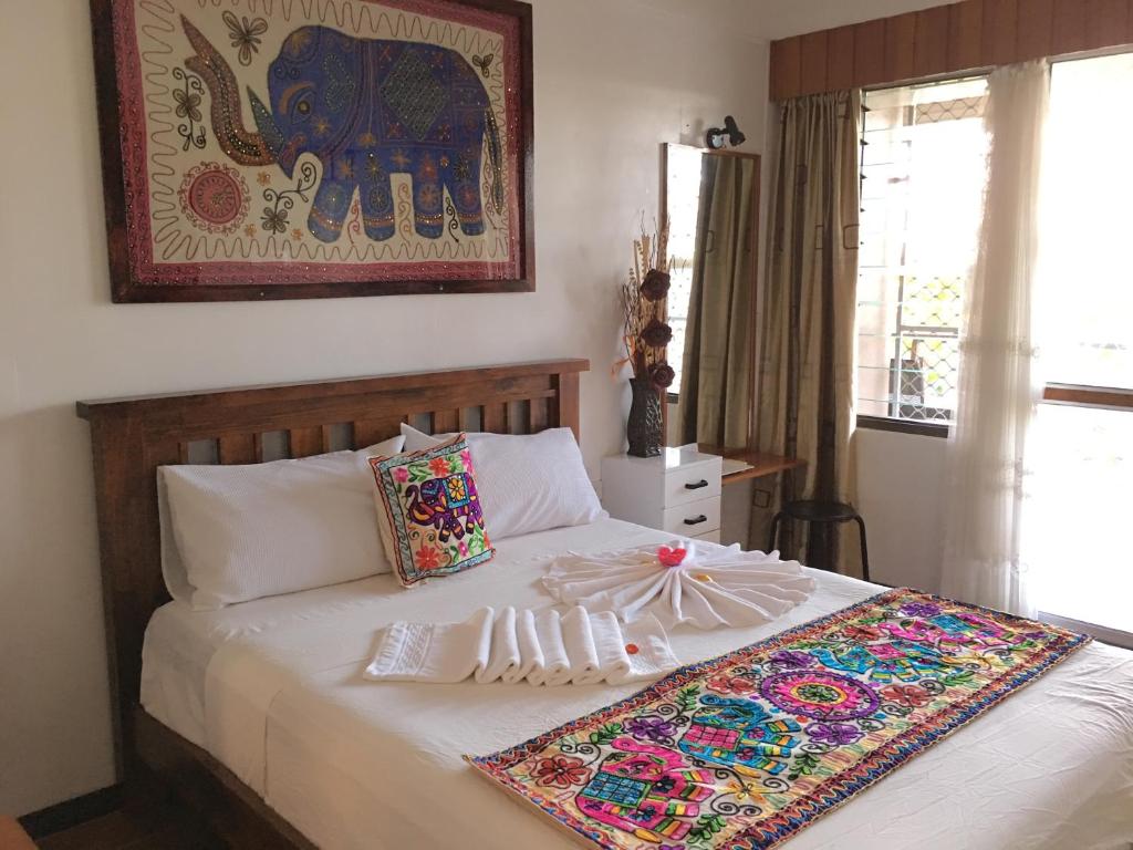 a bedroom with a bed with a blanket on it at Tagimoucia House Hotel in Suva