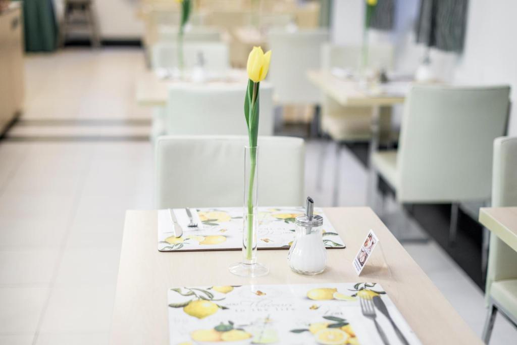 a yellow flower in a vase on a table at Hotel Páv in Prague