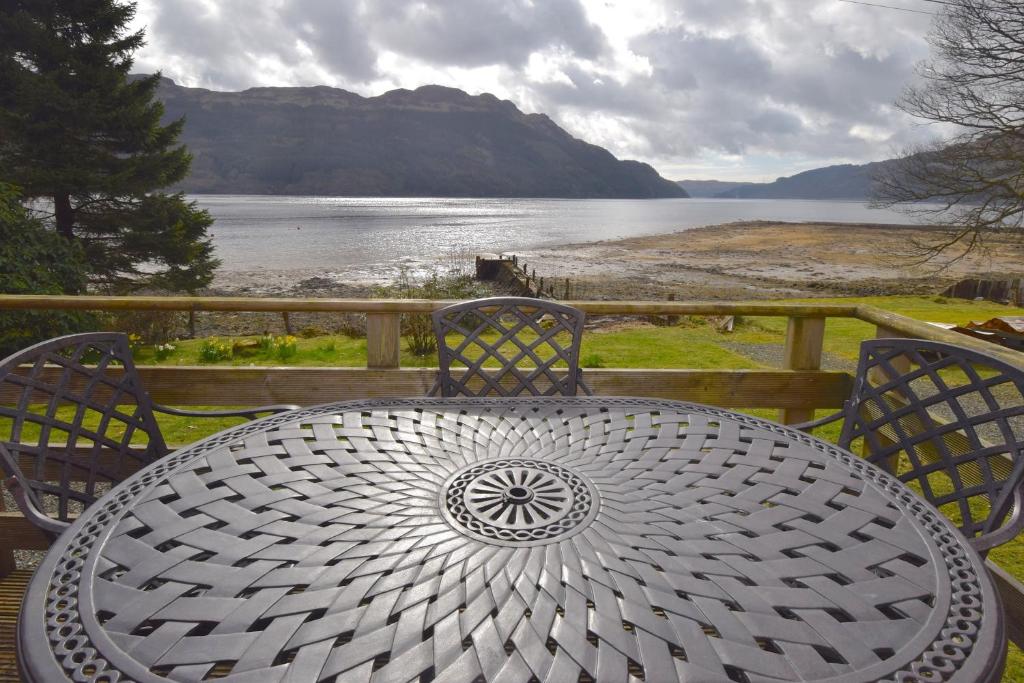 a table and chairs with a view of the water at Dalriada by Loch Goil in Carrick