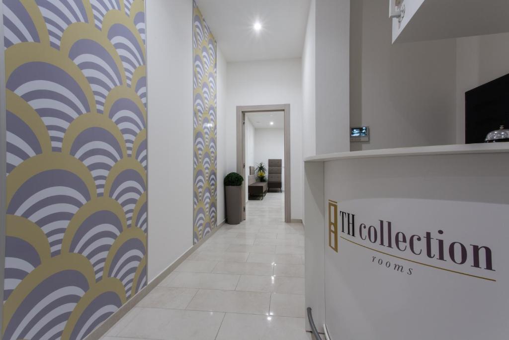 an office hallway with a reception counter and a wall mural at TH collection rooms in Oristano