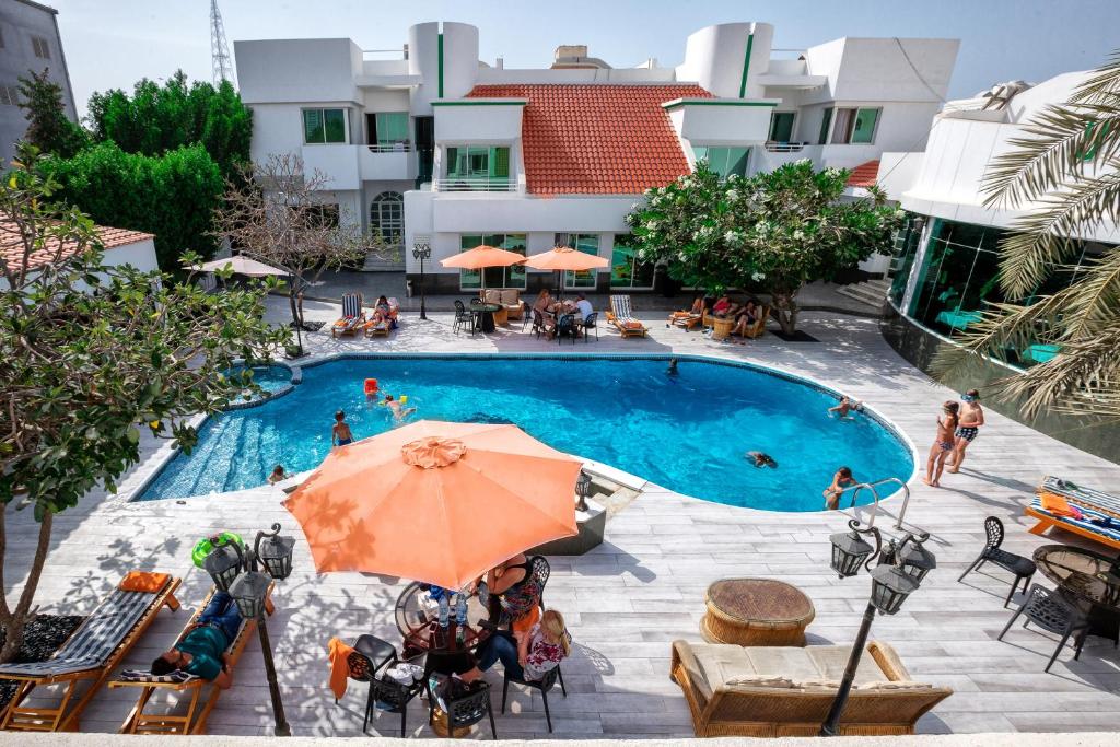 an overhead view of a swimming pool with an orange umbrella at Al Khalidiah Resort in Sharjah