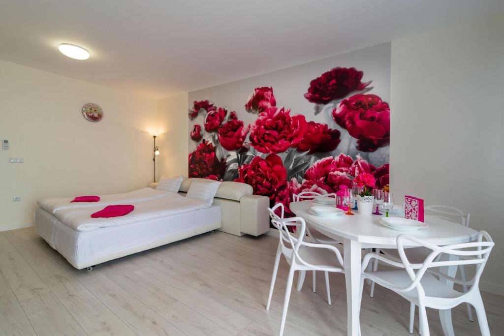 a bedroom with a bed and a table and red roses mural at Sea Star Kabakum Apartments in Golden Sands